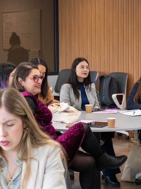 Un grupo de mujeres se encuentra sentadas en un aula participando en una actividad.