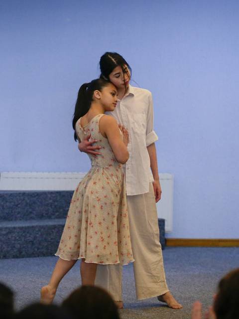 Dos mujeres están bailando en un escenario durante una actuación.