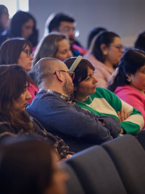 Un grupo de personas escucha atentamente en un evento o conferencia.
