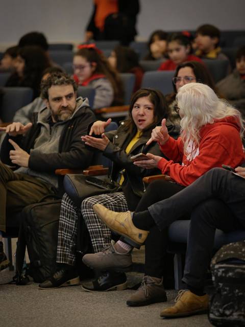 Un grupo de personas sentadas en un auditorio, participando en una conversación animada.