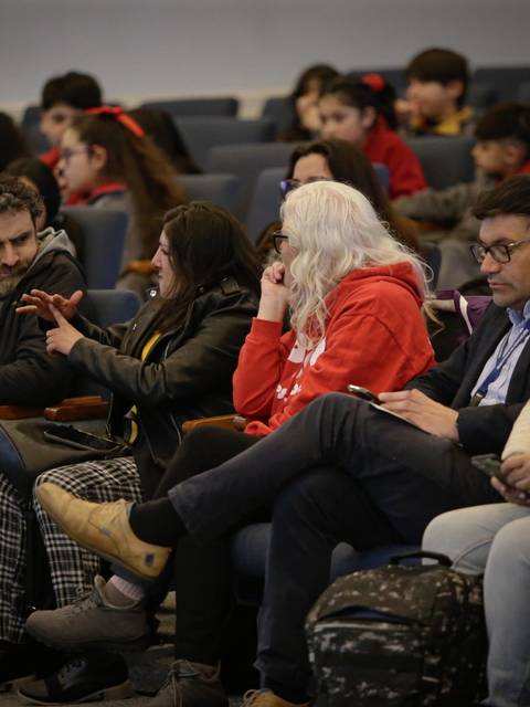 Un grupo de personas sentadas en un auditorio participando en una conversación animada.