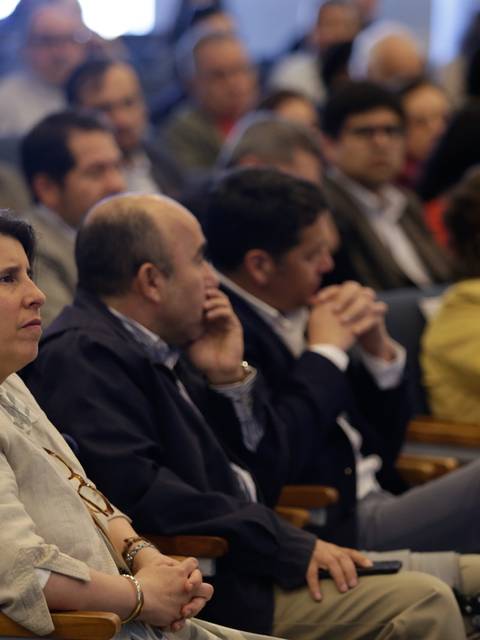 Un grupo de personas sentadas en una sala durante un evento o conferencia.