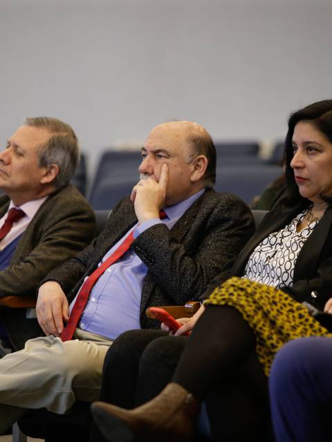 Un grupo de personas sentadas en un auditorio prestando atención a un evento.
