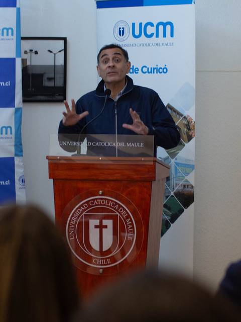 Un hombre se encuentra hablando en un podio durante un evento en la UCM.