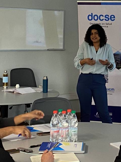 Una mujer está dando una presentación frente a un grupo de personas en una sala de reuniones.