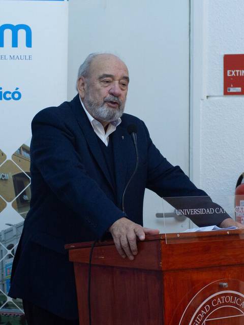Un hombre mayor habla en un evento en la sede de la Universidad Católica del Maule en Curicó.