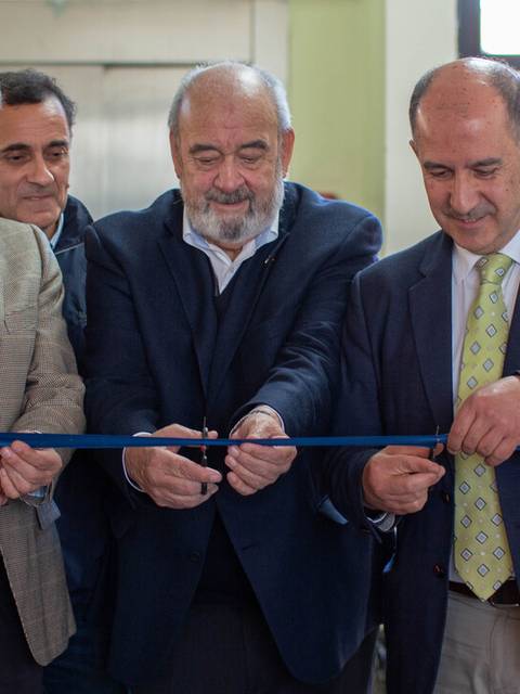 Cuatro hombres cortan una cinta en una ceremonia de inauguración.