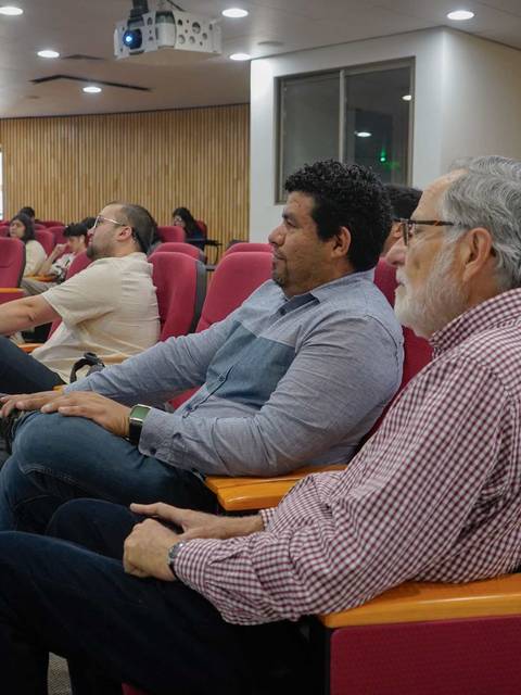 Un grupo de personas sentadas en un auditorio durante una presentación.