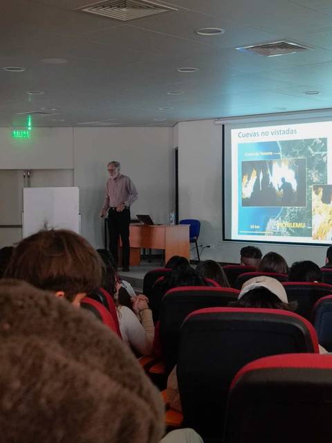Una conferencia en un auditorio donde se presenta información relevante ante un público atento.