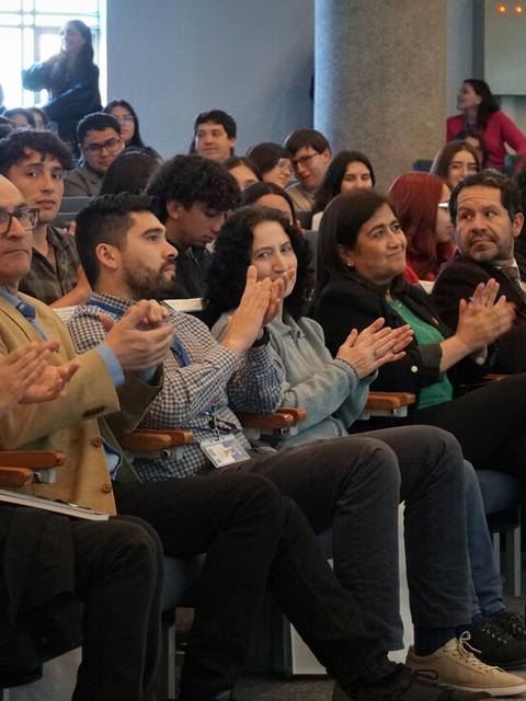 Un grupo de personas aplaudiendo en un evento o conferencia.