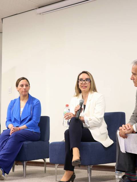 Una mesa redonda sobre economía y organizaciones sostenibles con tres ponentes discutiendo.