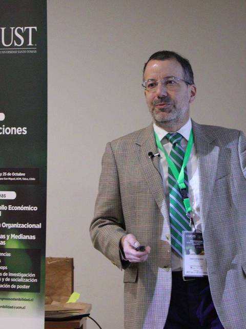 Un conferencista presenta en un congreso sobre economía y organizaciones sostenibles.