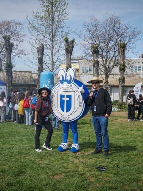 Un grupo de personas se encuentra en un evento al aire libre, con un personaje disfrazado y varios stands de información.