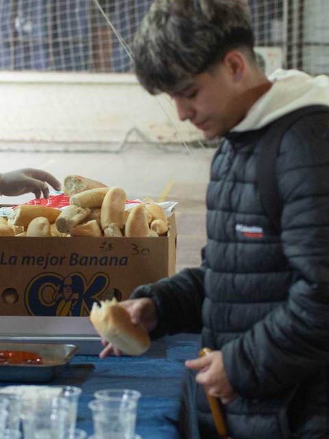 Un grupo de jóvenes se encuentra en un evento donde están sirviendo comida y bebida.