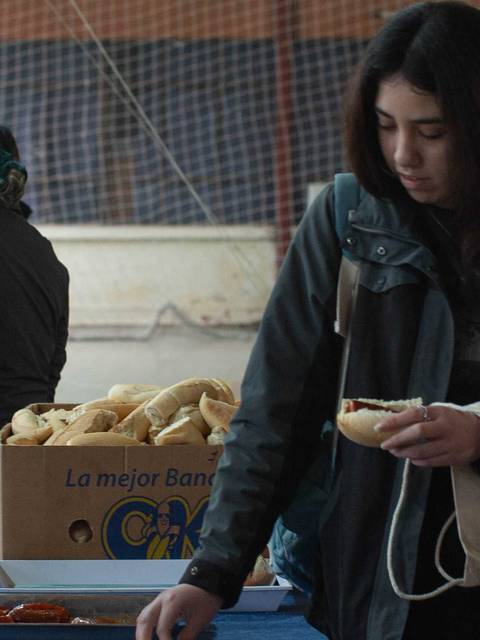 Un grupo de personas en un gimnasio donde se están sirviendo alimentos.