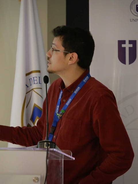 Un hombre presentando en un evento académico.