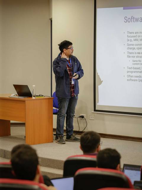 Un presentador expone un tema sobre software ante una audiencia en un aula.
