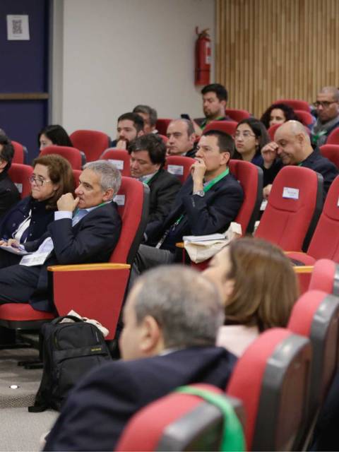 Un grupo de personas sentadas en un auditorio durante una conferencia.