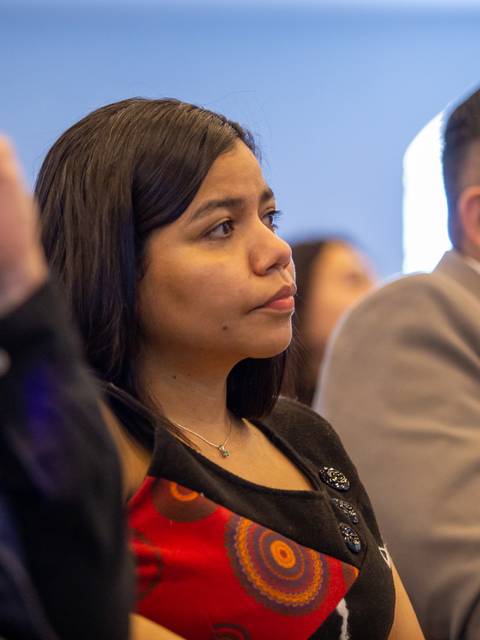 Un grupo de personas escucha atentamente en un evento.