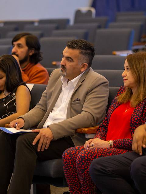 Un grupo de personas sentadas en una sala durante un evento o conferencia.