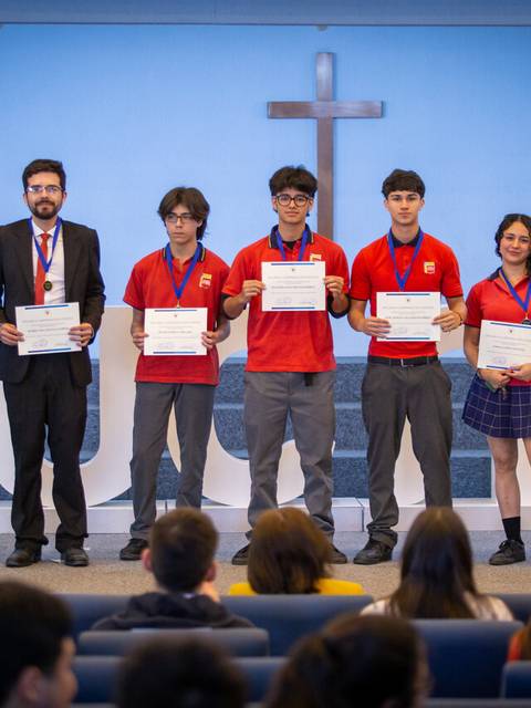 Un grupo de estudiantes celebra la entrega de certificados en un evento académico.