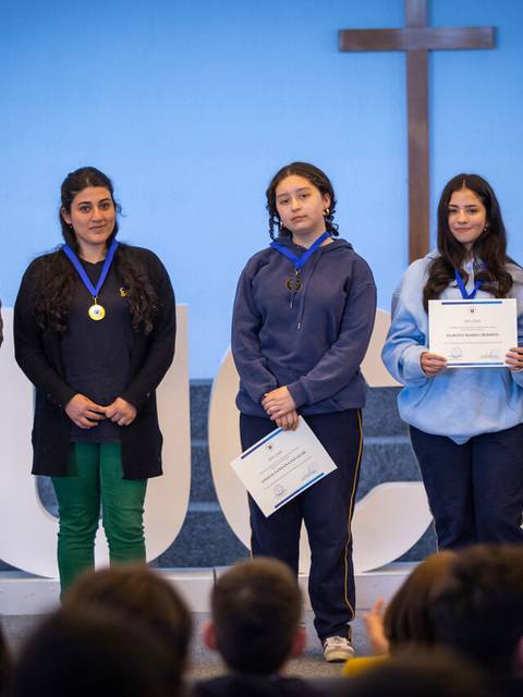 Un grupo de jóvenes recibió premios y reconocimientos en un evento escolar.