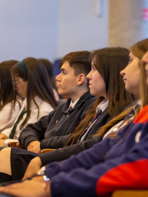 Un grupo de estudiantes escuchando atentamente en un evento académico.