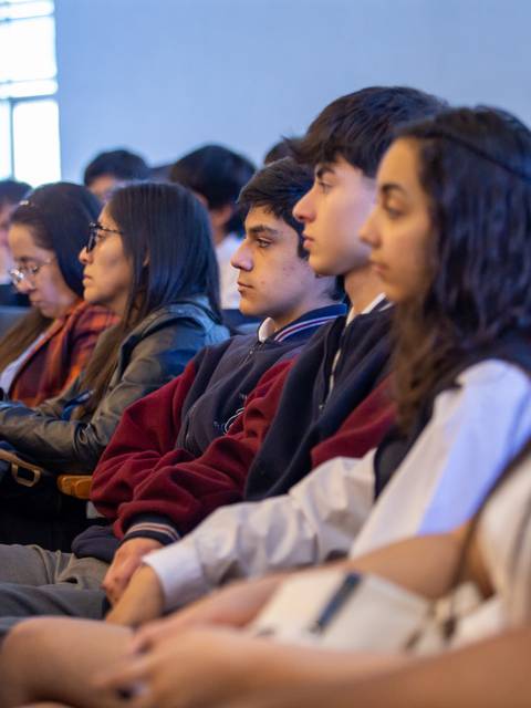 Un grupo de jóvenes sentados en un auditorio durante un evento.