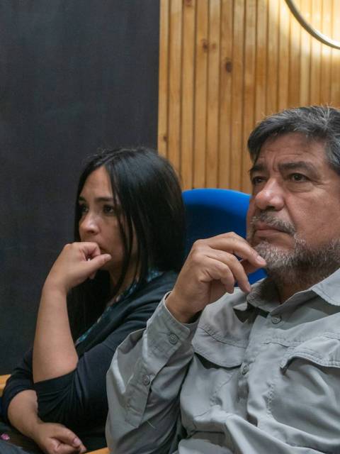 Un grupo de personas observa atentamente en un ambiente de sala de conferencias.