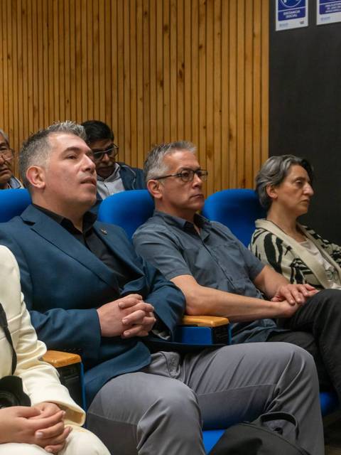 Un grupo de personas escuchando atentamente en una sala de conferencias.
