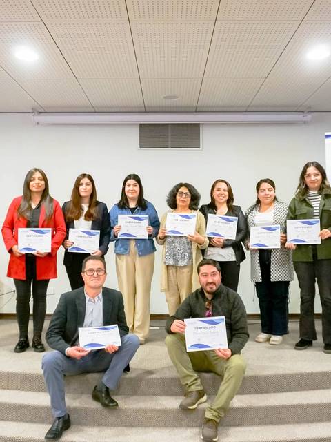 Un grupo de personas sostiene certificados en una ceremonia de entrega de reconocimiento.