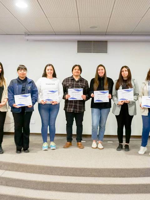 Un grupo de estudiantes sonrientes posando con sus certificados en un evento de la UCM.