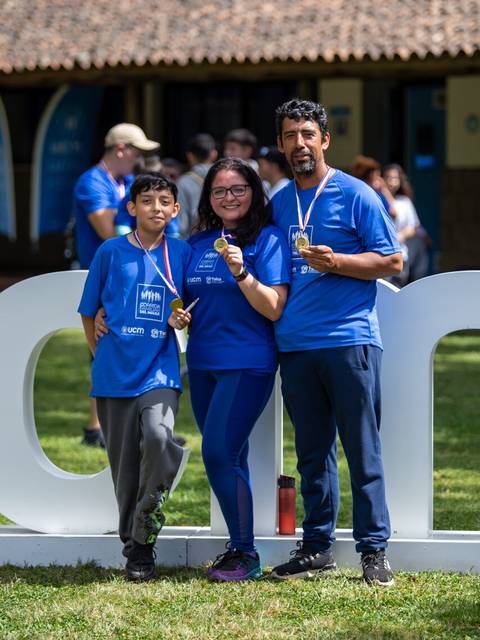 Una familia posando felizmente con medallas tras un evento deportivo.