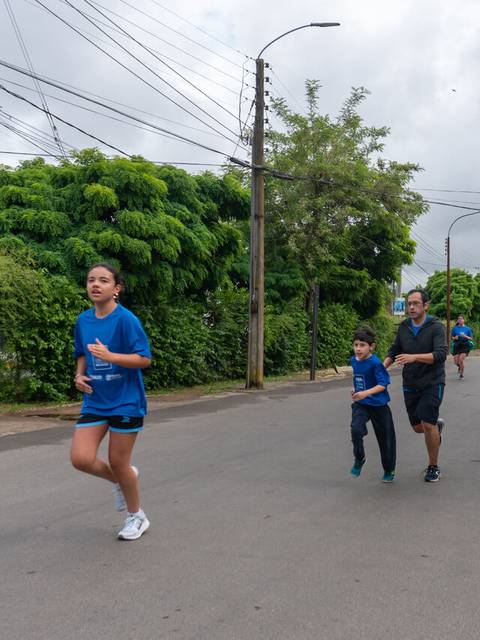 Un grupo de personas corre por la calle en un día nublado.