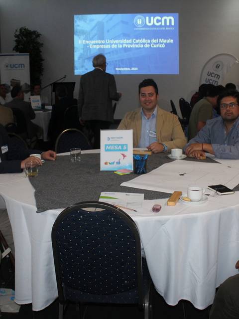 Un grupo de personas sentadas en una mesa durante un evento organizado por la UCM.