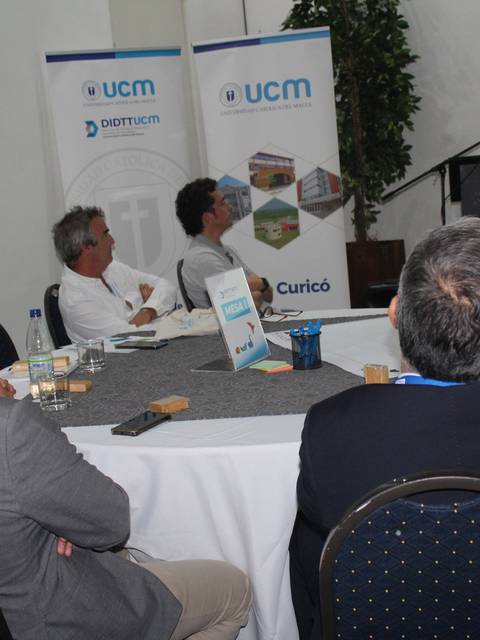 Un grupo de personas asiste a una presentación en un evento formal.