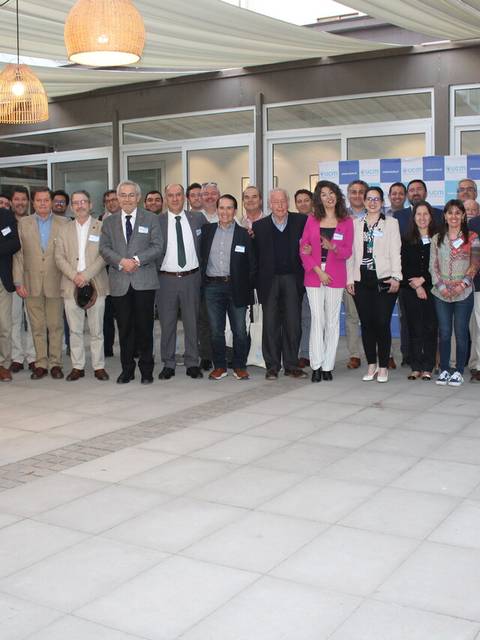 Fotografía grupal de un evento en un espacio al aire libre con varias personas posando para la cámara.