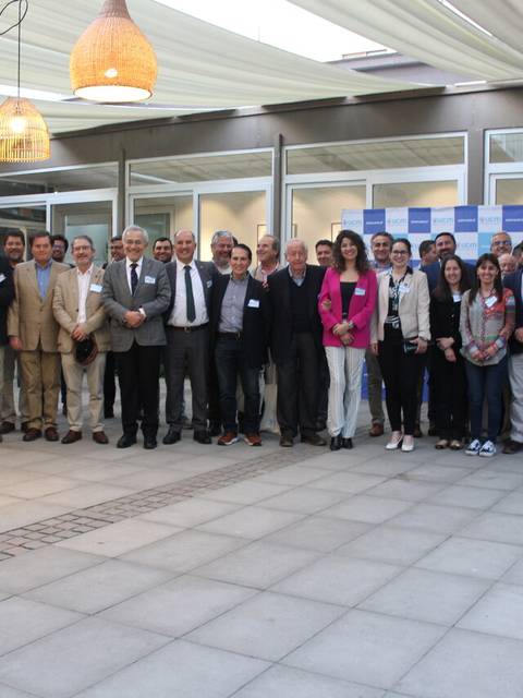 Un grupo de personas posando juntas en un espacio al aire libre con lámparas colgantes.