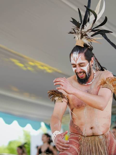 Un grupo de bailarines en trajes tradicionales realizan una danza en un evento cultural.