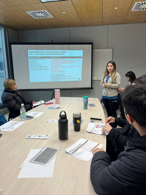 Una presentación en un entorno de trabajo sobre rehabilitación cardiovascular con varias personas participando.