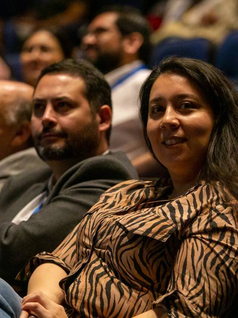 Un grupo de personas escuchando atentamente en una sala de conferencias.