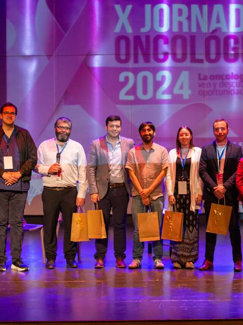Un grupo de personas posando en un escenario durante las X Jornadas Oncológicas 2024.
