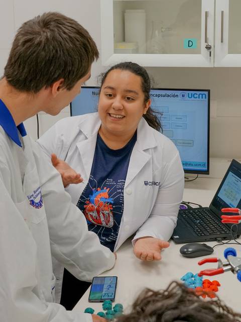Estudiantes en un laboratorio conversando sobre un proyecto.