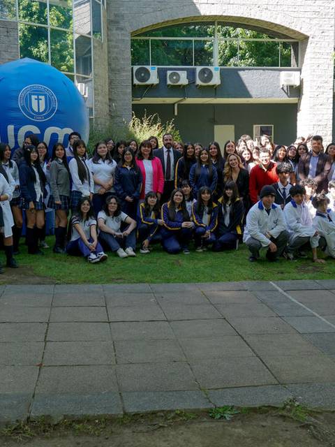 Grupo de estudiantes posando juntos en el campus universitario.