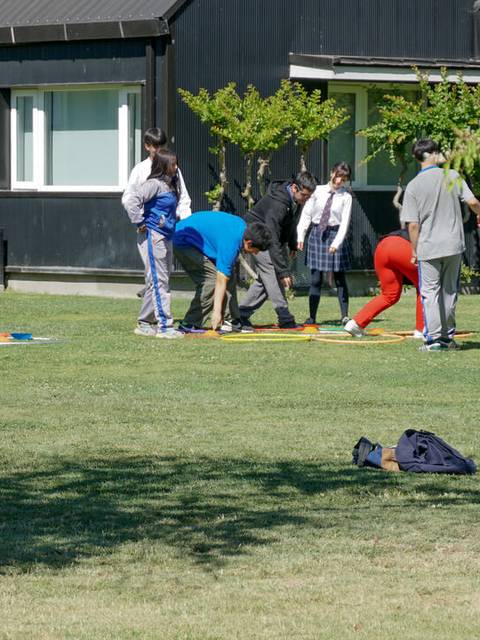 Un grupo de personas está jugando al aire libre en un espacio verde junto a un edificio.