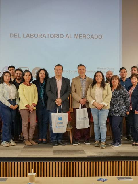 Un grupo de personas posando en un evento que se titula 'Del Laboratorio al Mercado'.