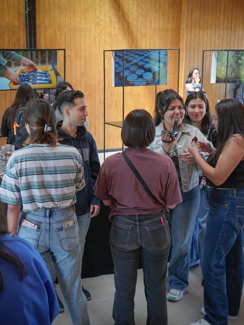 Un grupo de personas conversando en un evento en un ambiente moderno.