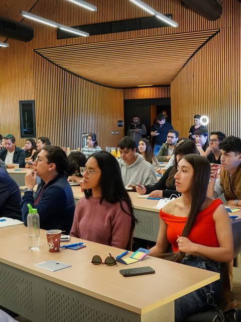 Un grupo de personas en un aula durante una conferencia o presentación.