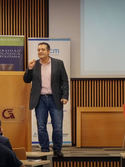 Un hombre presenta un discurso en una conferencia ante un público en un auditorio.