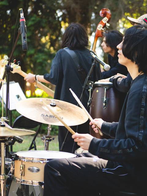 Un grupo de jóvenes músicos toca en un parque durante un concierto al aire libre.